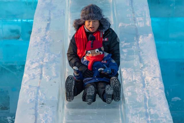 12月18日，在哈爾濱冰雪大世界園區，游客在體驗冰滑梯。 圖源：新華社