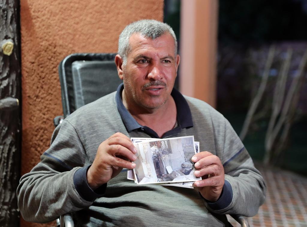 3月6日,在伊拉克北部萨拉赫丁省祖卢耶镇,阿卜杜拉·马哈茂德·易卜拉欣展示自己家被美军炸毁后的照片。新华社记者王东震摄