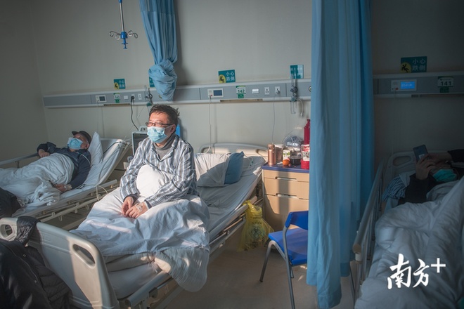 2月25日早上8点，阳光照进协和医院西院重症病房内，一位新冠肺炎患者起身望向窗外。享受着久违的暖阳。