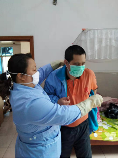 杨庆容照顾老人穿衣。 杨庆容照顾老人穿衣。
