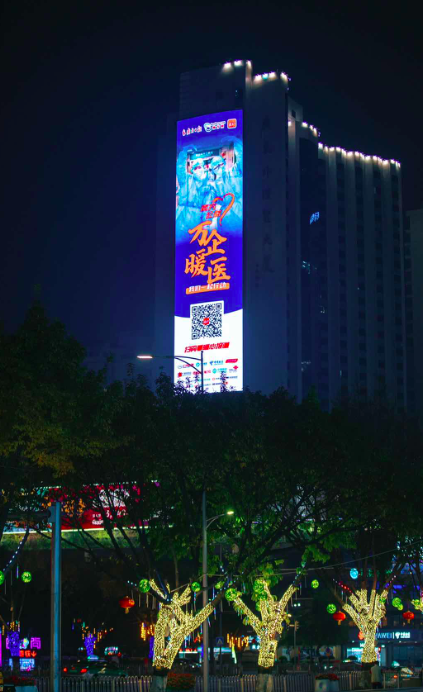 广州天河路外经贸大厦上，“万企暖医——我们在行动”主题海报点亮。