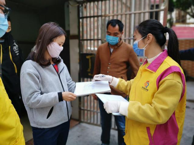 李嘉慧上门查访龚先生一家并送菜送日用品,检查他们的体温记录表。右为李嘉慧。 李嘉慧上门查访龚先生一家并送菜送日用品,检查他们的体温记录表。右为李嘉慧。