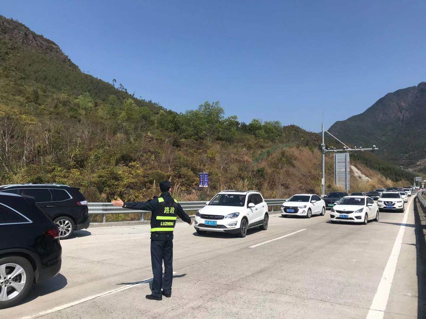 潮惠高速迎来返程高峰，路政员在莲花山服务区指挥车辆有序进出。