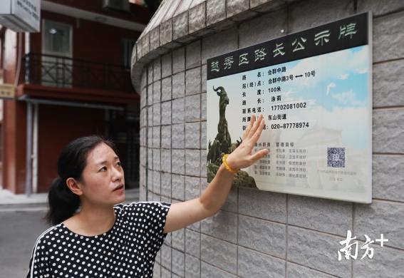 越秀区东山街新河浦社区党委书记涂莉站在她的路长公示牌前。