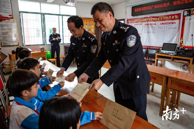 民警向当地贫困儿童送书信，鼓励他们自立。广州边检站供图