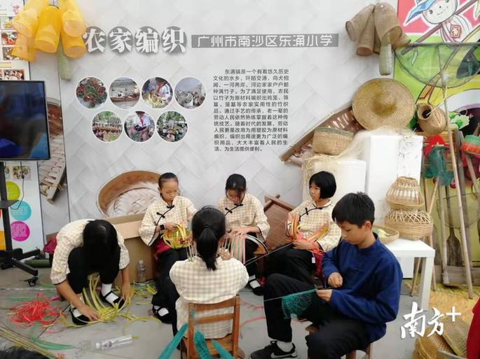 广州市南沙区东涌小学学生展示农家编织。