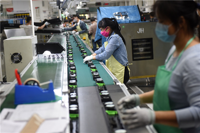 乐金电子的生产线上一片忙碌，工人戴着口罩在流水线上作业。