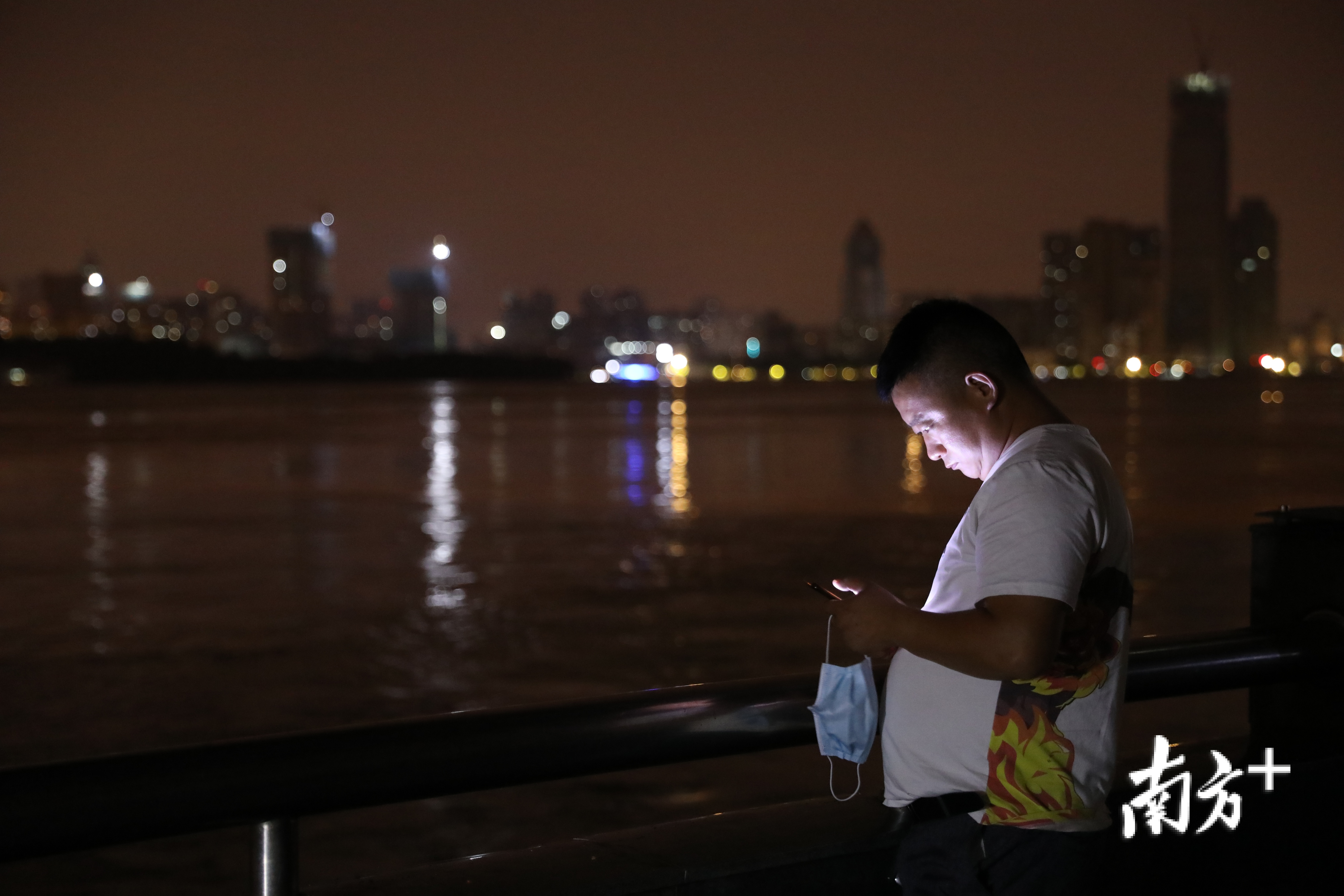 长江边上玩手机的市民