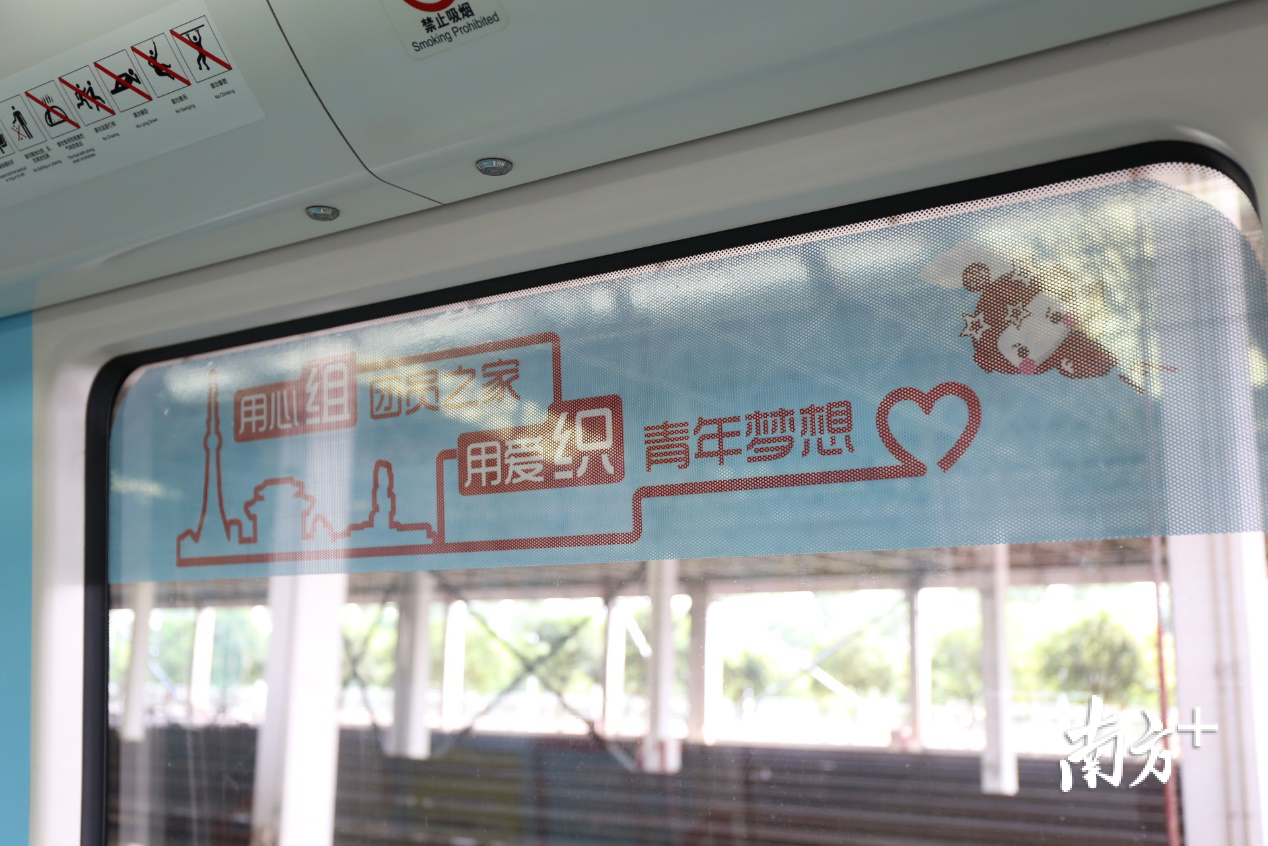 列车车窗印刷着“用心组团员之家，用爱”的字样，体现列车主题。