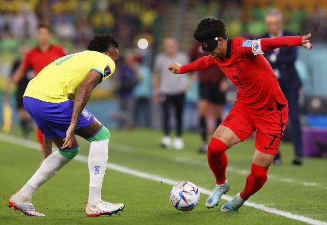 12月5日，巴西队球员米利唐（左）与韩国队球员孙兴民在比赛中拼抢。新华社发