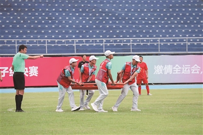 5月24日的足球赛中，“小海豚”志愿者协助转移受伤球员。