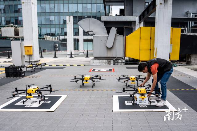 广东深圳，龙岗星河商圈，美团的工作人员为运送外卖的无人机固定打包好的外卖。