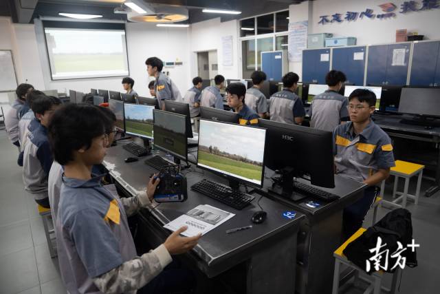 广州市机电技师学院，无人机专业的老师正在指导学生使用模拟机操作无人机。这是华南地区第一家开设无人机应用技术专业的公办院校。