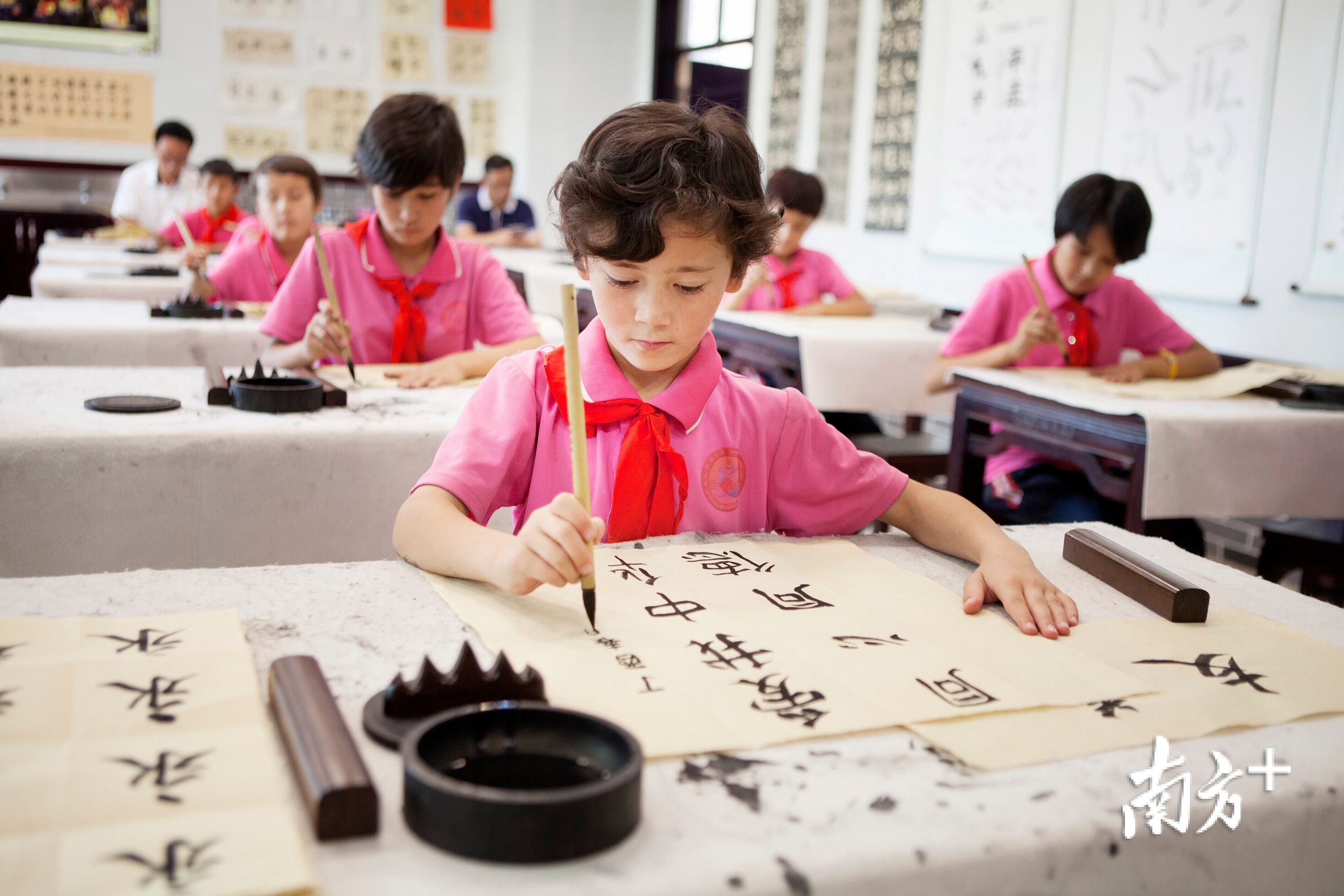 在新疆喀什疏附县托克扎克镇中心小学的书法教室，学生们正在认真书写“爱我中华”几个大字。学校希望通过书法教育，从小培育孩子们中华民族一家亲的意识。南方日报记者 朱洪波 摄