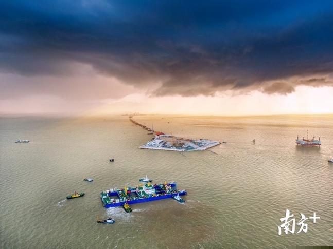 6月16日傍晚，在“一航津安1”沉管浮运安装一体船的提带下，E1管节驶向西人工岛。深中通道管理中心供图