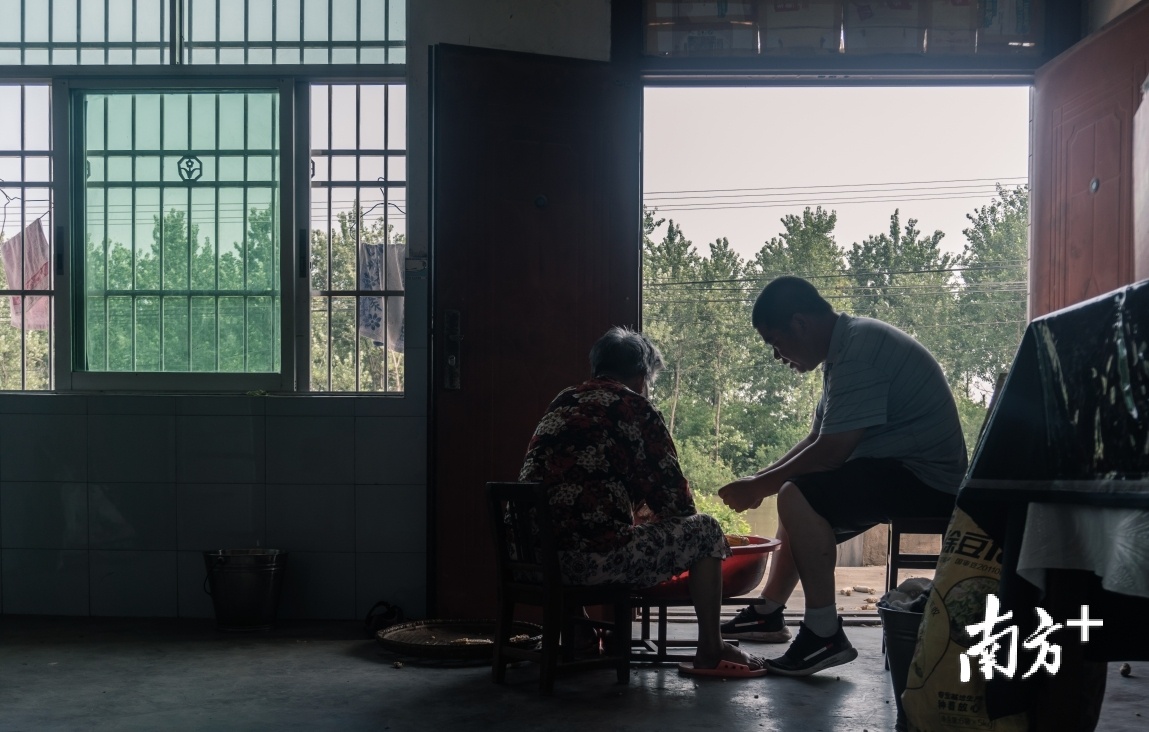 回到家后，代仁豹帮助老母亲剥刚晒好的玉米。