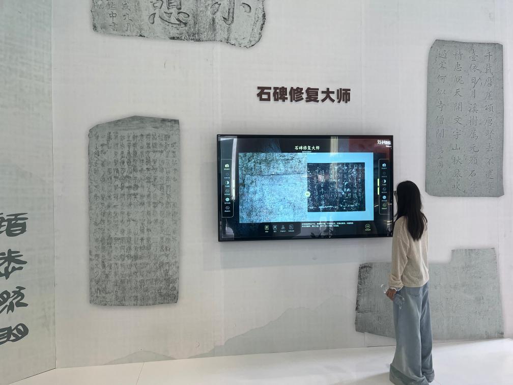 5月24日，在第二十一届文博会上，观众体验用数字技术修复石碑文字。新华社记者 陈宇轩 摄