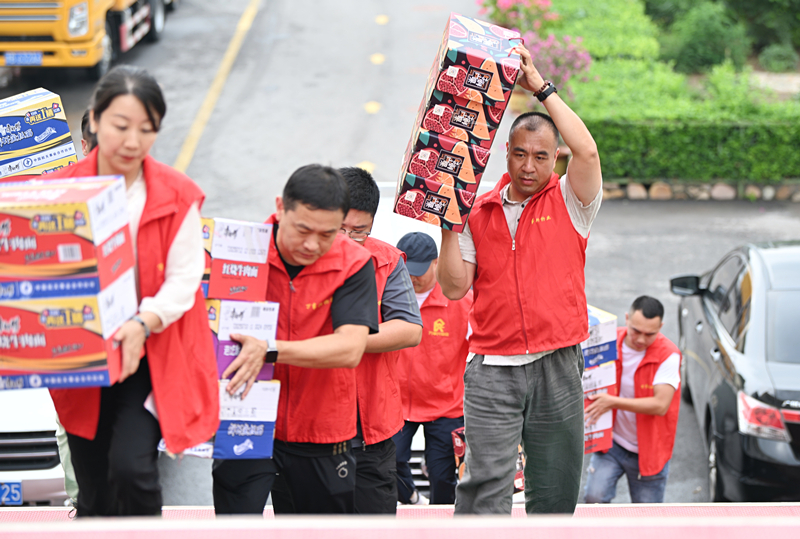 △我国全力做好关键期防汛抢险救灾工作，图为志愿者在天津市安置点搬运救援物资。