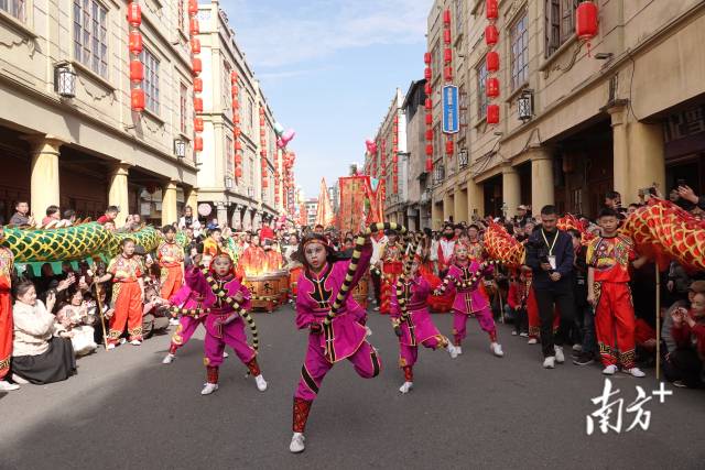 七位“时迁”扮相少年手持道具蛇，在骑楼间表演。受访者供图