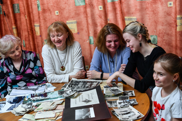 3月9日,援华专家西林之女叶莲娜 (左一)和家人在接受新华社记者采访时,一起翻看老照片。新华社记者曹阳摄