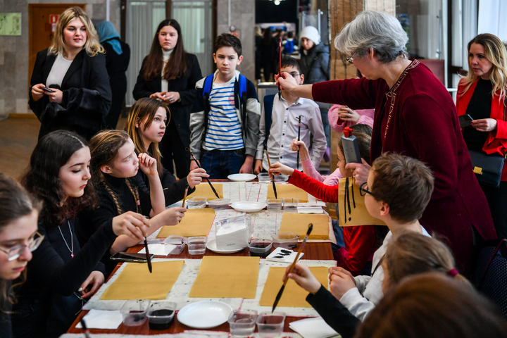 3月3日,在莫斯科国际关系学院,小朋友们在中国文化体验活动上学习使用毛笔。新华社记者曹阳摄