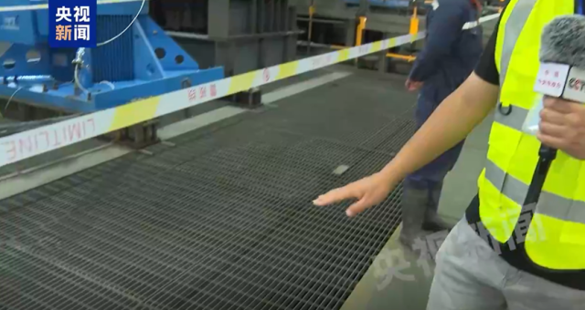 ▲央视记者在讲解涉事企业的格栅板及其他设备。（图片截自央视新闻画面）