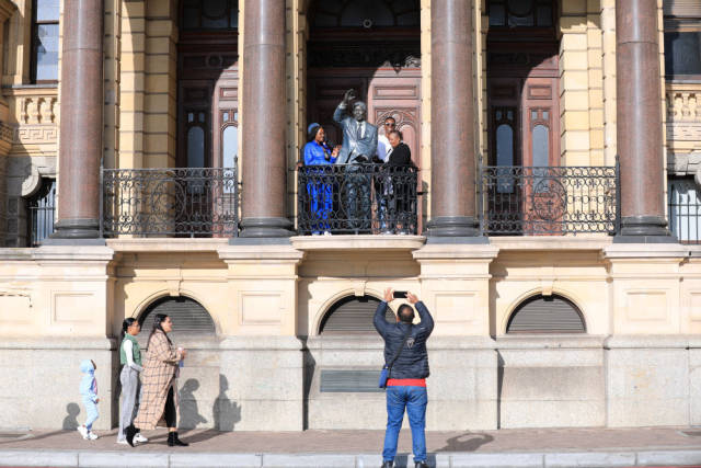 △游客在南非开普敦与曼德拉雕像合影。 游客在南非开普敦与曼德拉雕像合影。