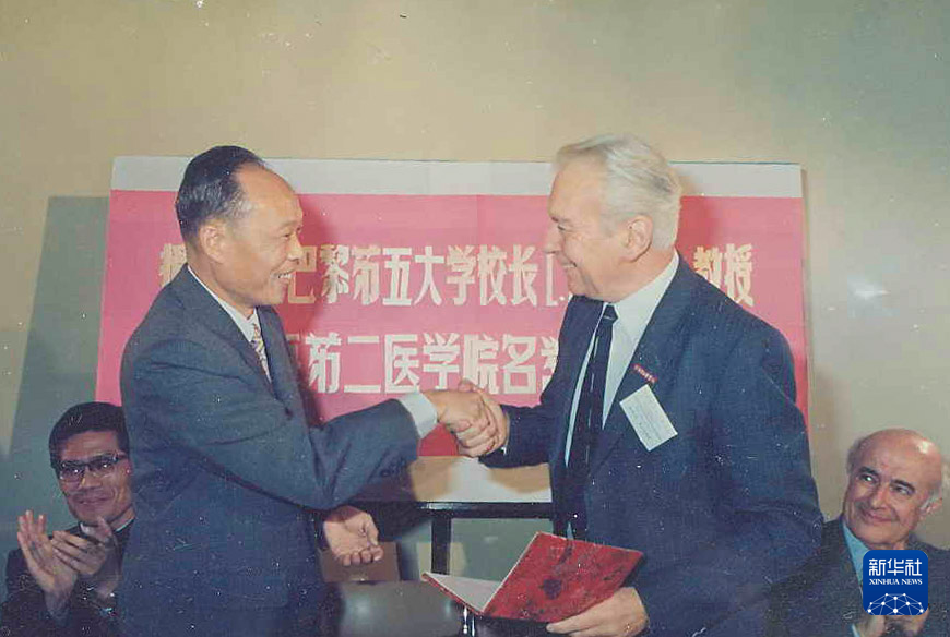 　　上海第二医学院（现上海交通大学医学院）校长王振义（前左）授予法国巴黎第五大学校长欧基埃名誉教授称号（摄于1985年）。新华社发（上海交通大学医学院供图）
