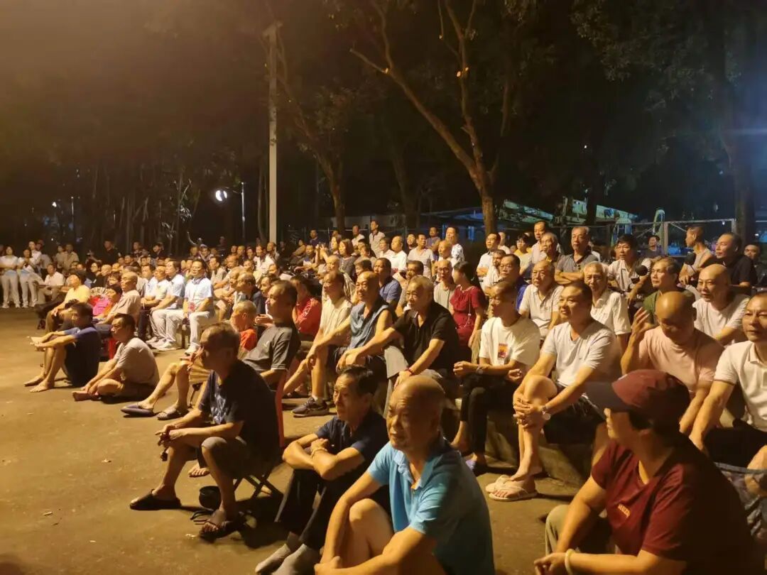 夜间的露天排球场，场边坐满了观众。