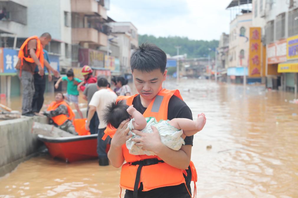 6月17日，灾情救援人员正在转移受灾群众。新华社发