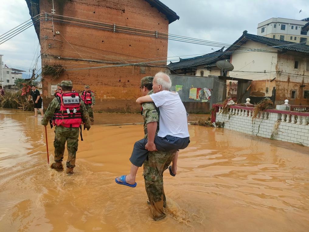 6月17日，救援人员正在转移受灾群众。新华社发
