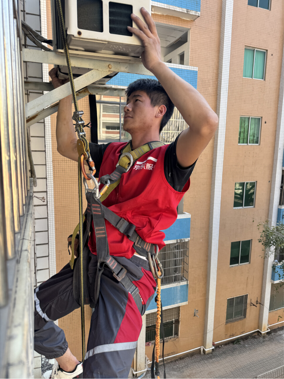 （任二黑在老旧小区拆卸空调外机）