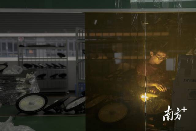 梵尔照明科技有限公司的生产车间内，工人正在逐一检查灯具产品。