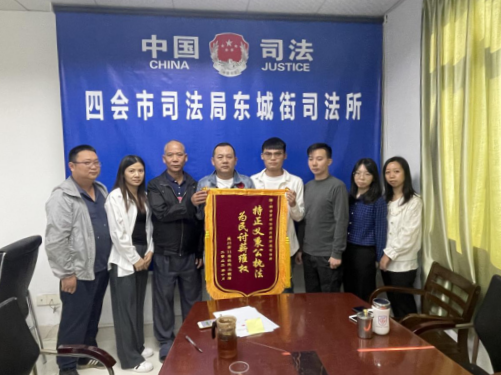 群众将锦旗送到东城街道工作人员手中。