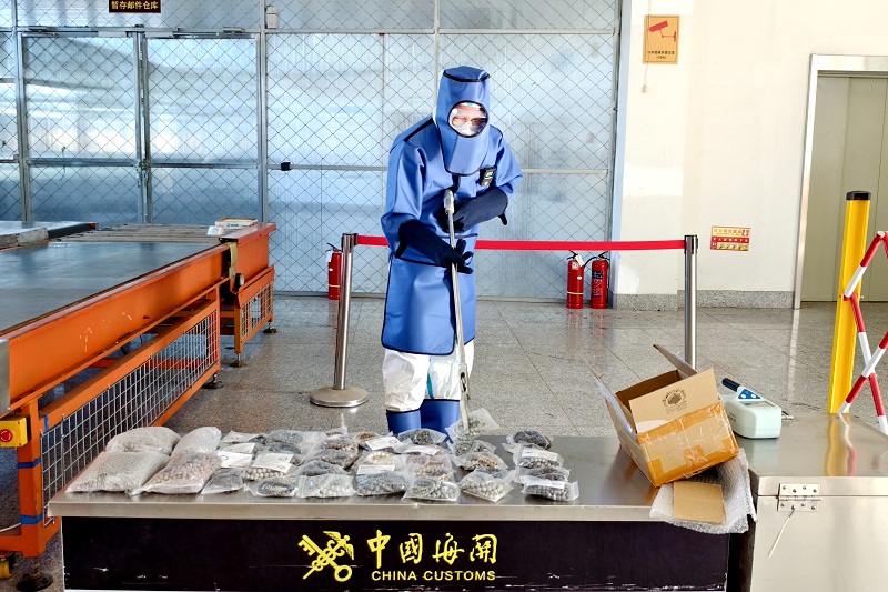 去年10月,丹东海关关员对放射性超标天然石首饰开展排查处置 图源:海关总署