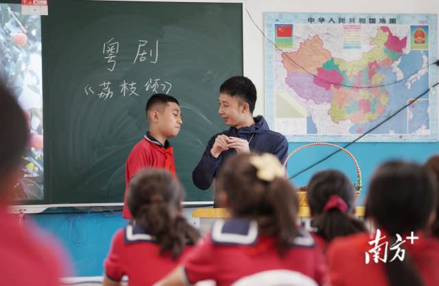 潘康友用从广州带来的荔枝干为道具，教孩子们学唱粤剧《荔枝颂》。