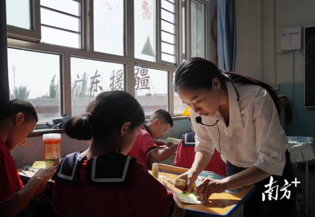 陆婉静正在给孩子们上剪纸课。