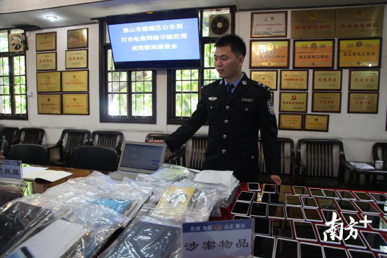 顺德区公安局民警展示查获的涉案物品。
