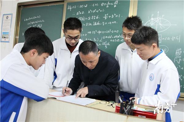 全国高中数学联赛优秀教练员王立新（中）在辅导学生。