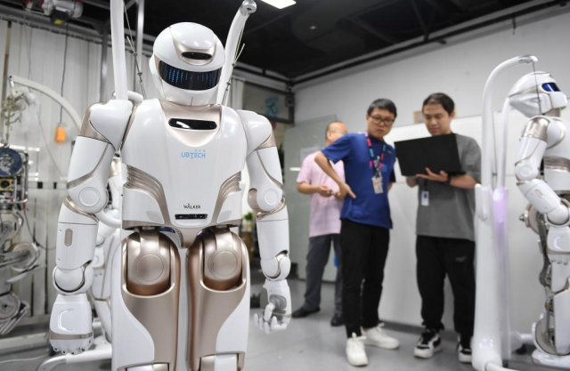 在位于深圳市南山智园的优必选总部，工作人员对人形机器人进行测试。图源新华社 