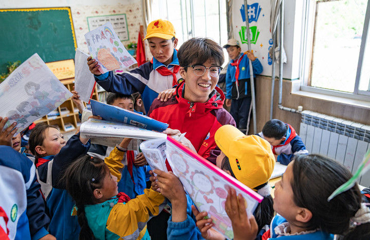 西藏林芝市工布江达县娘蒲乡中心小学地处海拔近4000米的高原，是布江达县海拔最高的学校。持续性的对口教育援藏工作有力补充了专业师资力量，改善了学校硬软件设施设备。这是2024年9月3日，西藏林芝市工布江达县娘蒲乡中心小学的孩子们，把自己做好的手抄报展示给岭南师范学院支教队队员胡正培。