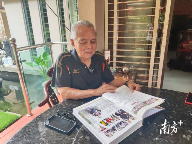 南侨机工后人杨国泰在翻阅写有父亲故事的书籍。 南侨机工后人杨国泰在翻阅写有父亲故事的书籍。