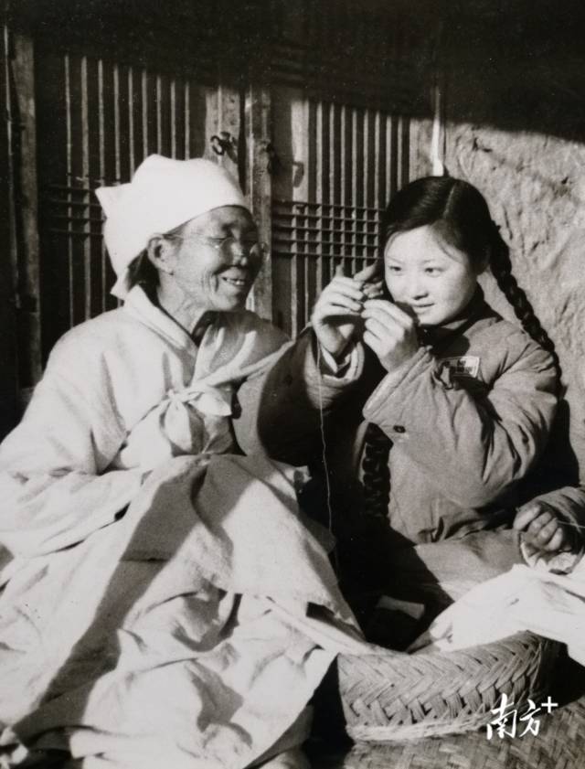 1952年，女战士贾梅为朝鲜孤寡老人金玉氏穿针，军文工团与驻地的朝鲜老乡生活在一起，结下深厚友谊。  