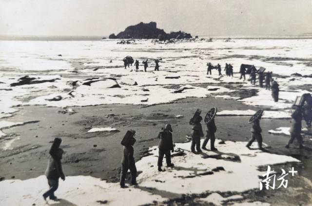 1952年，首当其冲的前沿阵地，守卫椴岛的战士们踏着冰排，将拆卸的平射炮、弹药和给养抢运到岛上。  