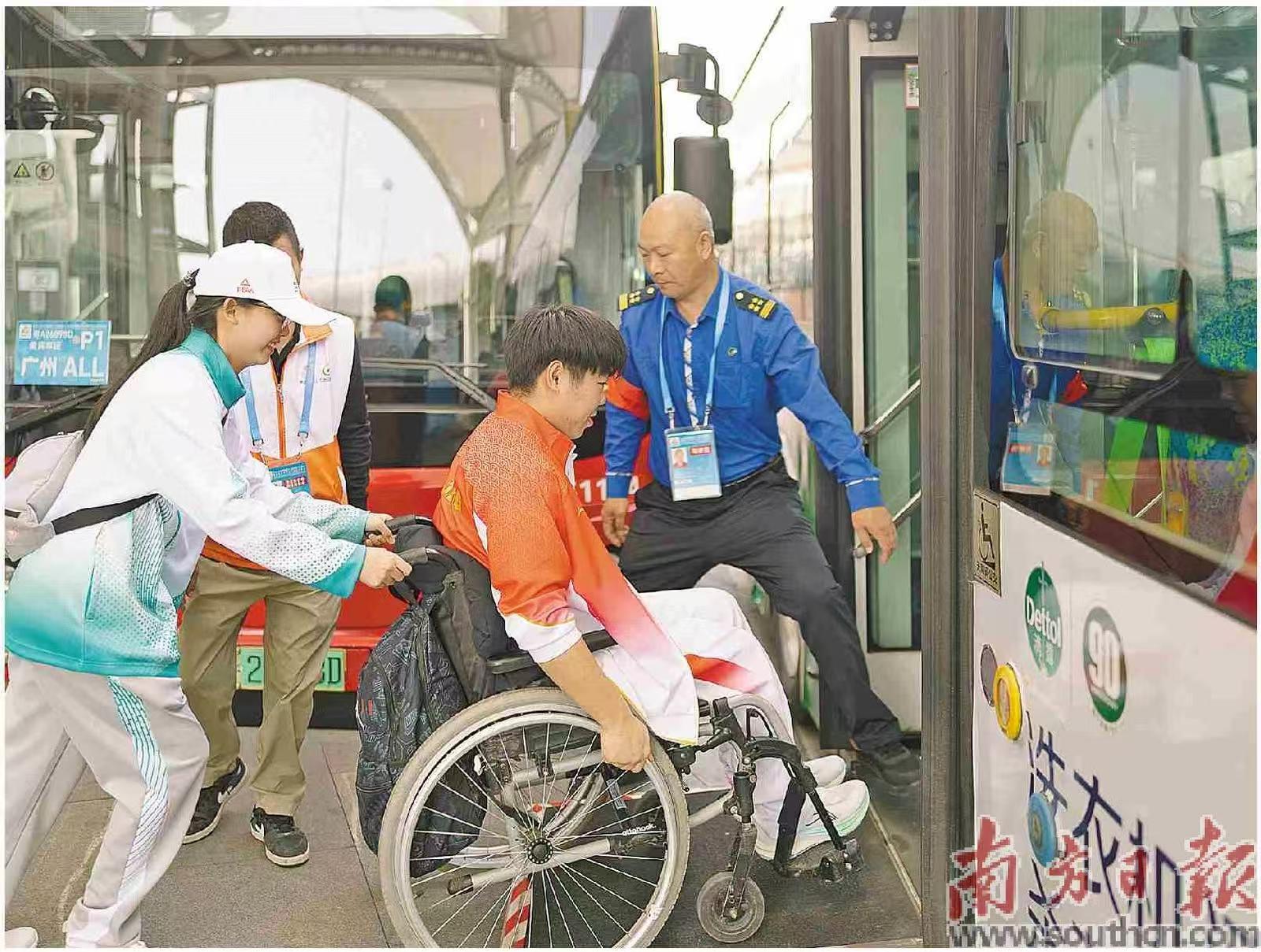 志愿者协助轮椅运动员登上转运巴士。 南方日报记者 梁钜聪 摄