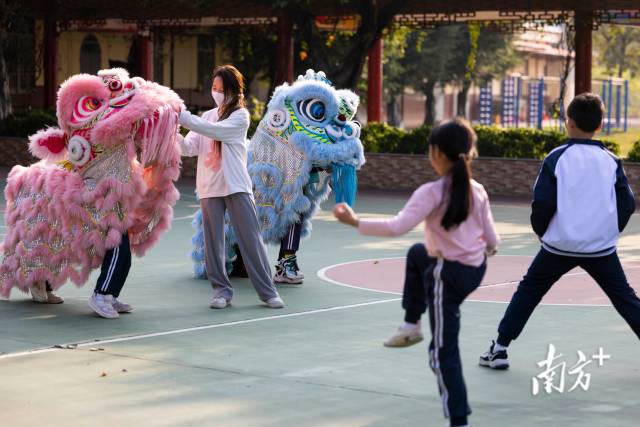 黄宝仪指导三洲小学的孩子们做基本的“三拜狮”动作。