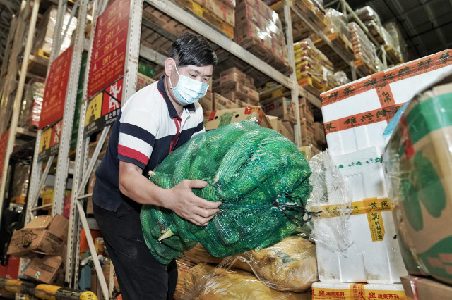 How are vegetables delivered to residents in areas under COVID-19 control?