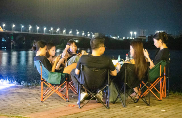 惠州东江边仍有部分流动摊贩,年轻人们坐在夜摊旁的江边聊天。 惠州东江边仍有部分流动摊贩,年轻人们坐在夜摊旁的江边聊天。