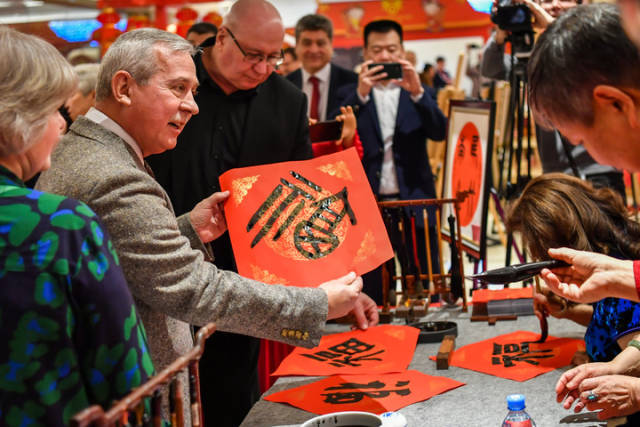 1月20日，在俄罗斯莫斯科举行的“欢乐春节—中国文化庙会”活动上，来宾接过福字。新华社记者 曹阳 摄