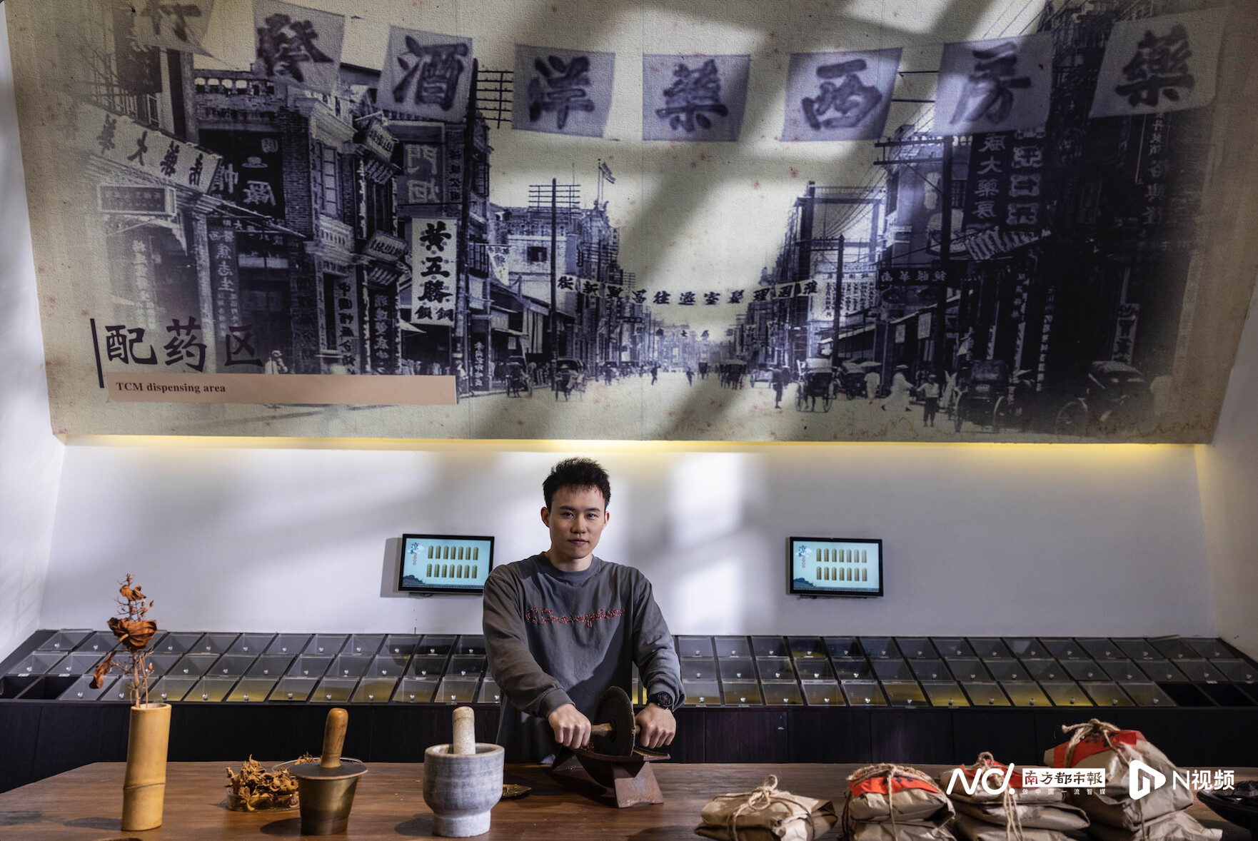 湾区民间文化探寻者谢思埸在广东省凉茶博物馆内体验碾药。
